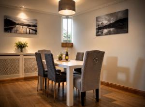 a dining room with a white table and chairs at Lomond Castle Penthouse in Luss