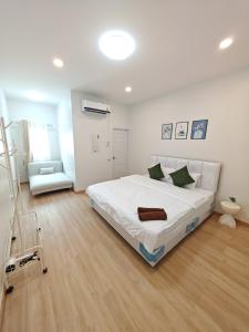 a white bedroom with a large bed and a chair at The paperwhite poolvilla khaoyai in Ban Tha Chang +14 photos