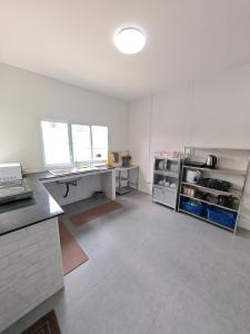 a large kitchen with white walls and a counter top at The paperwhite poolvilla khaoyai in Ban Tha Chang