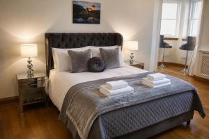 a bedroom with a large bed with towels on it at Lomond Castle Penthouse in Luss