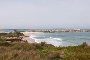 a beach with a bunch of people in the water at Swell House in Ferrel