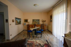 a living room with a table and blue chairs at Tiz Home il Tuo Rifugio di Charme nel Cuore della Sicilia autentica in Canicattì