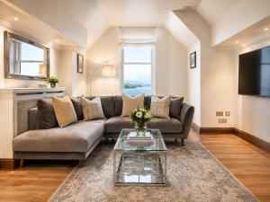 a living room with a couch and a tv at Lomond Castle Penthouse in Luss