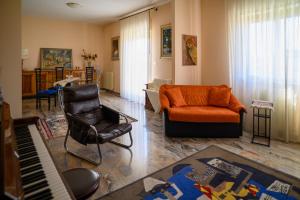 a living room with a couch and a chair and a piano at Tiz Home il Tuo Rifugio di Charme nel Cuore della Sicilia autentica in Canicattì