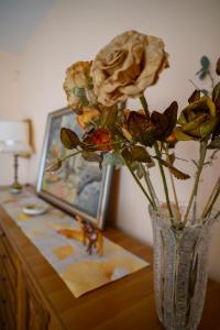 a vase with a rose sitting on a table at Tiz Home il Tuo Rifugio di Charme nel Cuore della Sicilia autentica in Canicattì