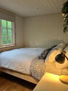 a bedroom with a bed with a lamp on a table at Half Moon Shepherds Huts in Plumpton