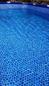 a blue swimming pool with blue tiles in it at Panorama Gora in Kutaisi