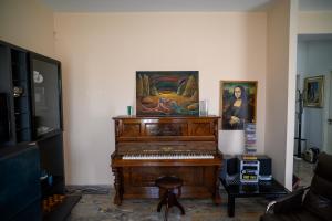 a piano in a living room with a painting on the wall at Tiz Home il Tuo Rifugio di Charme nel Cuore della Sicilia autentica in Canicattì +53 photos