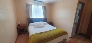 a small bedroom with a bed and a window at Hostal Internacional Valdivia in Valdivia