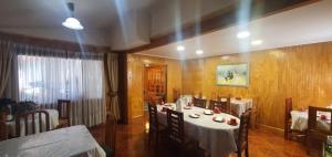 a dining room with a table and chairs in a room at Hostal Internacional Valdivia in Valdivia +1 photo