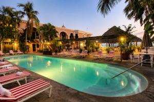 a swimming pool with lounge chairs and a building at Hotel Santa Fe in Puerto Escondido
