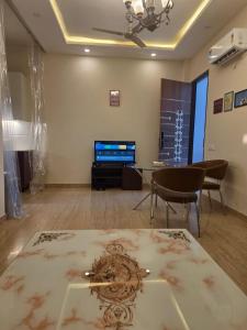 a living room with a table and a tv at The Cozy Theory in Kharar
