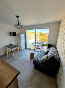 a living room with a couch and a table at Entre Terre et Mer, logement cosy in Poussan