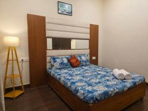 a bedroom with a bed with blue and white sheets at The Cozy Theory in Kharar