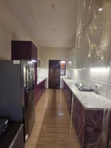 a kitchen with a stainless steel refrigerator and wooden floors at The Cozy Theory in Kharar +30 photos