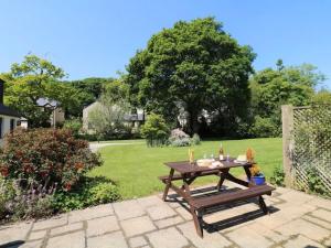 a picnic table and a bench in a garden at Yarg Cottage in Falmouth