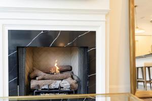 a fireplace in a living room with a mirror at Hotel Burg in Leesburg