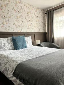 a bedroom with a bed with a floral wallpaper at The Cross Keys in Worthington