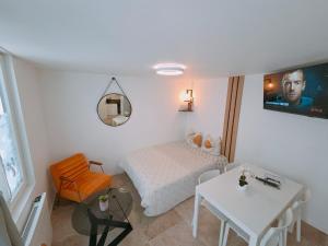 a small white room with a bed and a table at Duplex Hyper centre-ville 10 in Quimper