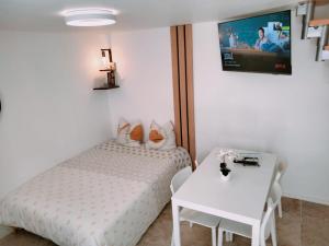 a small bedroom with a bed and a table at Duplex Hyper centre-ville 10 in Quimper