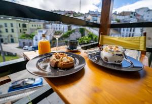 a table with a plate of food and a glass of wine at Hotel A. G. Porcillan in Ribadeo
