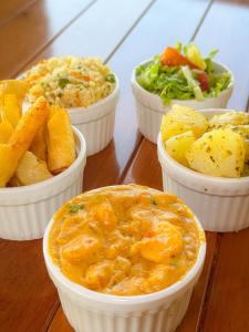 a group of four bowls of food on a table at Pousada Sunrise Beach in Cumbuco