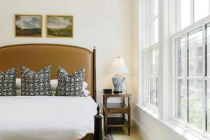 a bedroom with a bed and two windows at Hotel Burg in Leesburg