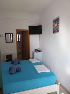 a bedroom with a blue bed with a television on the wall at Sobe Kraft 1 in Živogošće