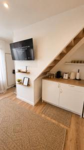 a kitchen with a staircase with a tv on the wall at Appartement JM in Cherbourg en Cotentin