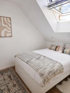a white bed in a room with a window at Appartement JM in Cherbourg en Cotentin