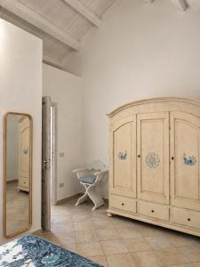 a bedroom with a large wooden cabinet and a mirror at Appartamento il Caracolo a Cala Francese in La Maddalena