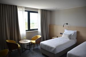a hotel room with a bed and a table and chairs at Hotel Dom in Studenci