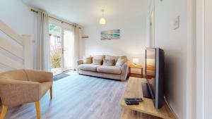 a living room with a couch and a tv at 39 Strawberry Hill, Tolroy Manor in Hayle
