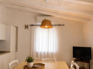 a dining room with a table and a television at Appartamento il Caracolo a Cala Francese in La Maddalena