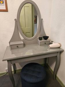 a dressing table with a mirror and a blue stool at Quirky hideout in town centre in Wimborne Minster