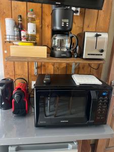 a black microwave sitting on top of a counter at Gîte de Jean-Benoit in Le Passage