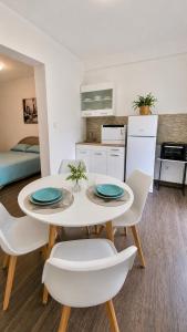 a kitchen and dining room with a white table and chairs at Apartments Vista Muo 2026 NEWLY RENOVATED in Kotor