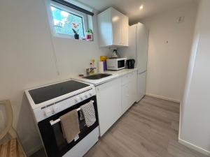 a small kitchen with a stove and a refrigerator at Spacy flat with big garden in Södertälje