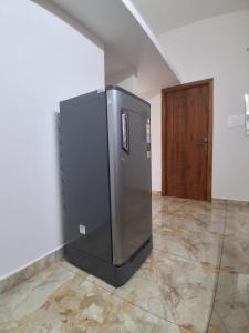 a refrigerator in the corner of a room with a door at Srivaari Residency Villa in Pondicherry