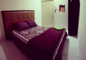 a bedroom with a large bed with purple sheets at DKajang Villa Homestay Kajang in Kajang