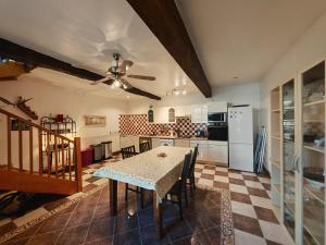 a kitchen with a table and a ceiling fan at Gite du Paradis in Vieuzos