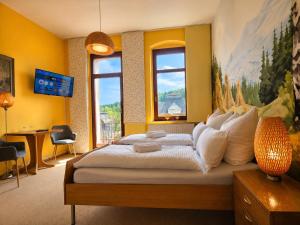 a bedroom with a large bed with yellow walls at YFB Frühstückspension Weiße Rose I Zentral gelegen in Bad Elster