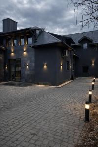 a house with a brick driveway in front of a building at Willa Czarny Puzzel in Tarnowska Wola