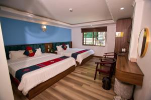 a hotel room with two beds and a chair at Harmony Haven Hotel in Sapa