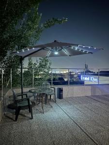 a table and chairs under an umbrella on a roof at Khan Boutique Hotel in Almaty