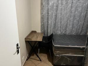 a desk and a chair in a room with a curtain at Namahadi Stay in Vereeniging