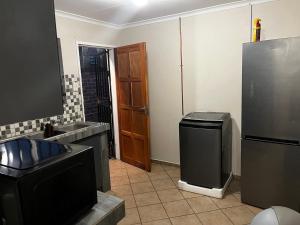 a kitchen with a refrigerator and a trash can at Namahadi Stay in Vereeniging