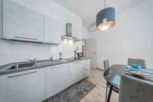 a kitchen with a sink and a table in a room at Historic Hub - Crociere a 10 min - AC - WiFi Gratis in Savona