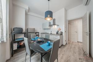 a kitchen and dining room with a table and chairs at Historic Hub - Crociere a 10 min - AC - WiFi Gratis in Savona +18 photos