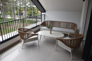 a balcony with a couch and a table and chairs at Hotel Dom in Studenci
